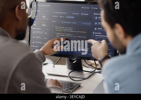 Adult Men Reviewing Cybersecurity Code in Information Technology Office Stock Photo