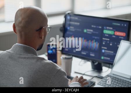 Adult Man Monitoring Data Dashboard in Information Technology Office Stock Photo