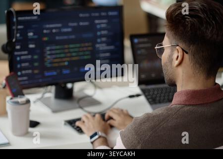 Adult Man Coding at Workstation in Information Technology Office Stock Photo