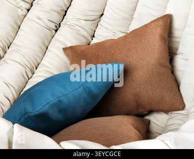 Multi-colored pillows close-up. Blue and brown pillows on a soft chair. Stock Photo