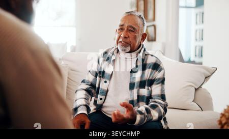 Consulting, talking and therapy with old man on sofa for mental health or trauma counseling. Conversation, diagnosis or feedback and senior patient in Stock Photo