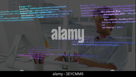 Male dev typing at desk while code overlay appearing, scrolling, obscuring screen for software Stock Photo