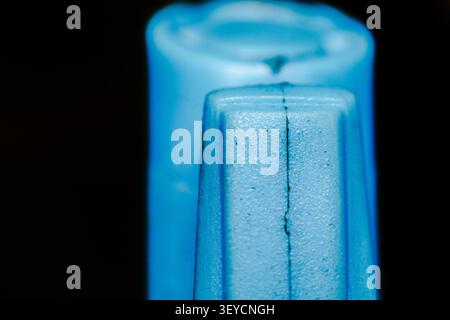 Close up macro photography showing texture of blue plastic molded object against black background with shallow depth of field and soft lighting detail Stock Photo