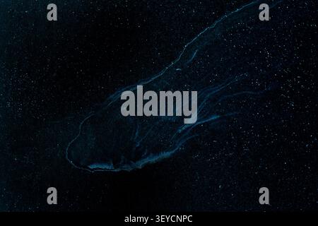 Abstract cosmic fluid art texture with dark blue nebula waves and starry glitter on black background Stock Photo