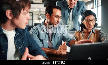Laptop, discussion and business people in office with review on app development project. Meeting, feedback and team of web designers with manager for Stock Photo