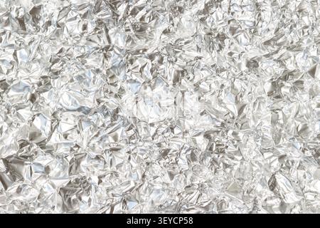 Crumpled aluminum foil horizontal macro closeup filled with wrinkled metallic wrap abstract background texture Stock Photo
