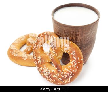 Traditional German pretzel with sesame seeds and clay cup of fresh milk isolated on clean white background copy space template Stock Photo