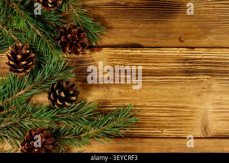 Christmas composition with fir tree branches and cones on wooden background. Top view, copy space Stock Photo