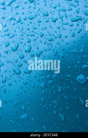 Abstract macro of water droplets on a turquoise painted textured surface, creating a fresh aquatic background Stock Photo