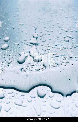 Blue abstract close-up of water droplets on a painted textured surface with cool tones Stock Photo
