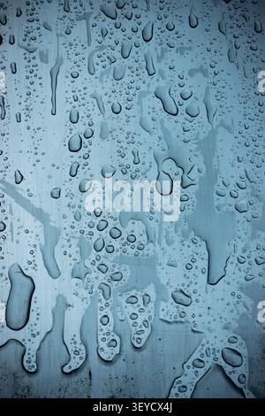Blue abstract close-up of water droplets on a painted textured surface with cool tones Stock Photo