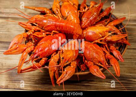 Boiled crayfish in plate on wooden table Stock Photo