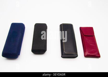 A selection of coloured cases made from different materials for the transport and protection of spectacles or glasses placed on a white background Stock Photo