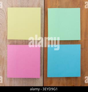 Four Pastel Sticky Notes on Wooden Board Stock Photo