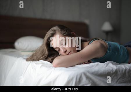 Young woman with long hair sleeping peacefully in bed Stock Photo