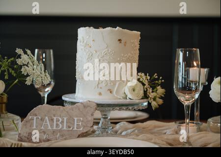 Elegant white wedding cake on a beautifully set table Stock Photo