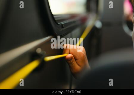 Passenger pulling bus stop request cord while riding the city bus Stock Photo