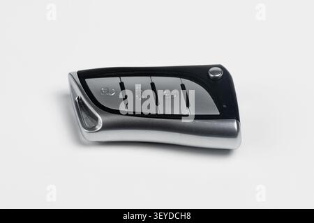 Close-up view of a sleek modern car key fob (remote control) isolated on a clean white background. The silver and black automotive keyless entry remot Stock Photo