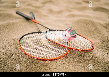 Badminton Shuttlecock and Racket on Sandy Beach. pink shuttlecocks and rackets on a summer day. The concept of outdoor sports games Stock Photo