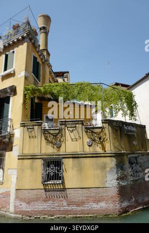 Old yellow house on a canal in Venice Stock Photo