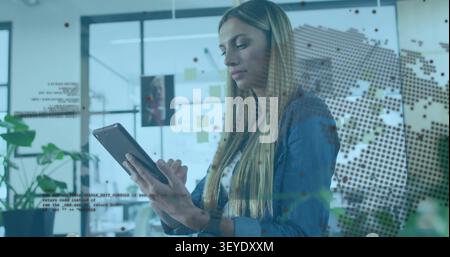Woman tapping tablet, activating dotted world-map overlay in business, analyzing global trends Stock Photo