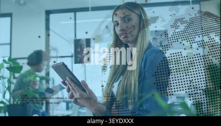 Woman tapping tablet, activating dotted world-map overlay in business, analyzing global trends Stock Photo