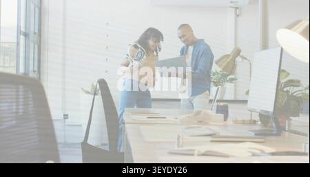 Woman holding white VR headset, man tilting laptop initiating tech reviewing and working with UI Stock Photo