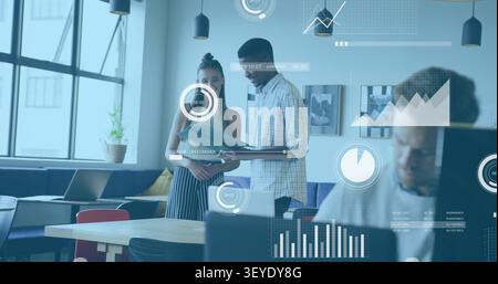 Two colleagues reviewing blue folder for project data in office, opening pages causing HUD charts Stock Photo