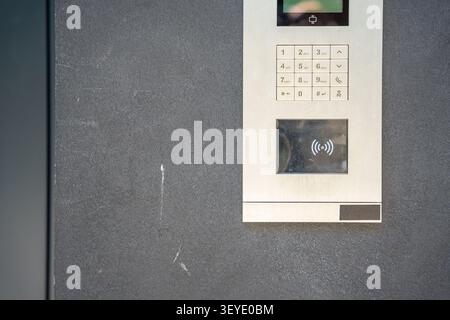 Modern apartment building intercom with keypad and contactless access system. Secure residential access highlights smart building technology and Stock Photo