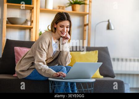 Young female designer, freelancer working in the office. Female using laptop to searching info. Stock Photo