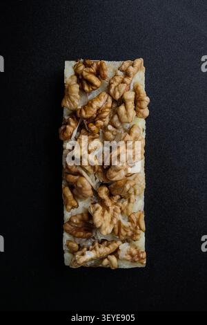 Walnut topped rice cake bar on dark textured background with rustic natural food styling Stock Photo
