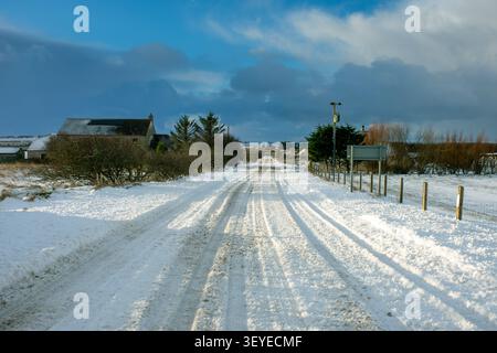 The main Thurso to John o'Groats road, the A836, snow covered in winter.  At the village of Mey, Caithness, Scotland, UK Stock Photo