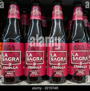DENIA, SPAIN - November 15, 2025. Bottles of red beer are neatly arranged on supermarket shelves in Spain. Shoppers explore local craft options during Stock Photo
