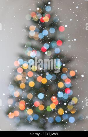 Vertical festive background with smaller cool-toned bokeh lights and a more defined Christmas tree silhouette on a clean white background. Falling sno Stock Photo