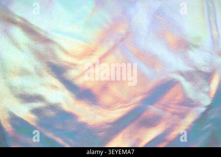 Iridescent holographic fabric texture with pastel metallic sheen and abstract rainbow background Stock Photo