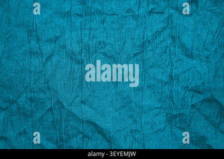 Teal fabric texture with wrinkled cloth surface and creased textile detail for background use Stock Photo