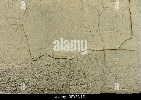Aging plaster shows intricate cracks and textures, capturing the essence of time and character on a weathered wall. Stock Photo