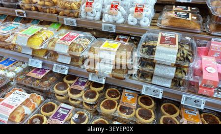 Toronto, ON, Canada - June 8, 2026 Assorted prepackaged sweet baked goods and pastries are displayed on wooden shelves in the bakery section of a loca Stock Photo