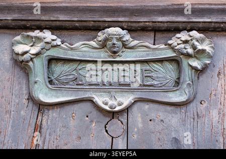 An old, art-nouveau style letterbox in a door in Udine, Northern Italy. Stock Photo