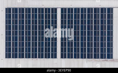 Aerial view of solar panels mounted on a light-colored wall, showcasing sustainable green energy technology in Diepenbeek, Belgium. Stock Photo