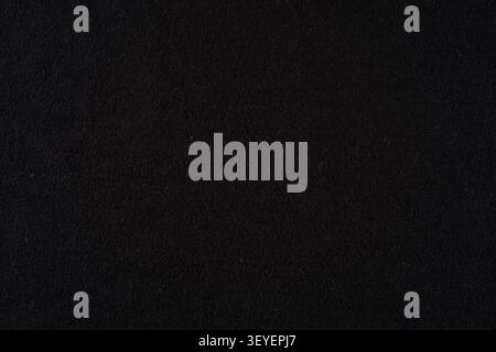 Black felt fabric close-up showing soft, dense texture and subtle fibers; a versatile dark textile background ideal for design, product photography ba Stock Photo