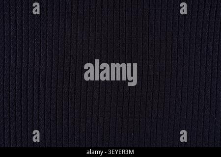 Close-up of navy blue ribbed knit fabric showing vertical texture and soft wool fibers, ideal as a background or textile detail for fashion, apparel d Stock Photo