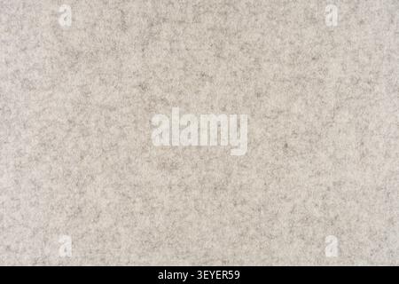 Neutral beige felt fabric close-up showing soft woolen texture and subtle mottled pattern, ideal as a background for design projects, presentations, a Stock Photo