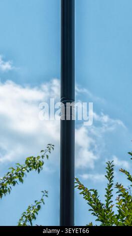 A black outdoor street light pole in front of the sky Stock Photo