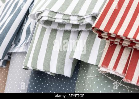 assorted striped and polka dot pattern fabric rolls background Stock Photo