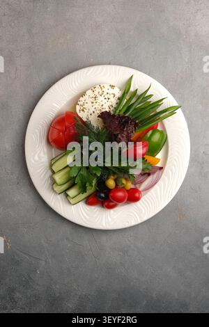 Fresh vegetable salad arrangement on white plate with herbs and colorful sliced produce Stock Photo
