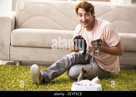 Young man playing with kitten at home Stock Photo
