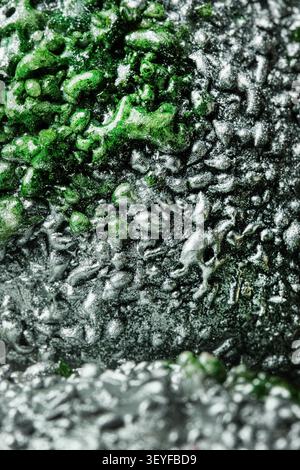 Abstract closeup of rough green and silver textured surface with glossy metallic details Stock Photo