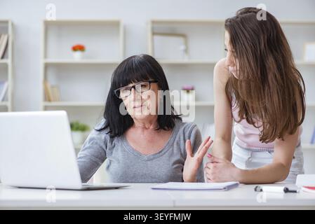 Daughter explaining to mom how to use computer Stock Photo