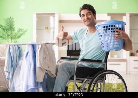Disabled man on wheelchair doing laundry Stock Photo